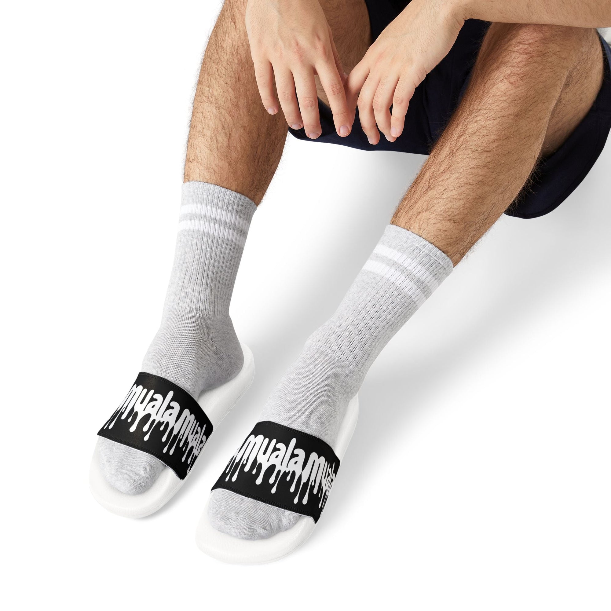Men's white Muala® flip fat flop sandals with black adjustable straps and white logo worn with gray socks, styled for casual comfort and durability.