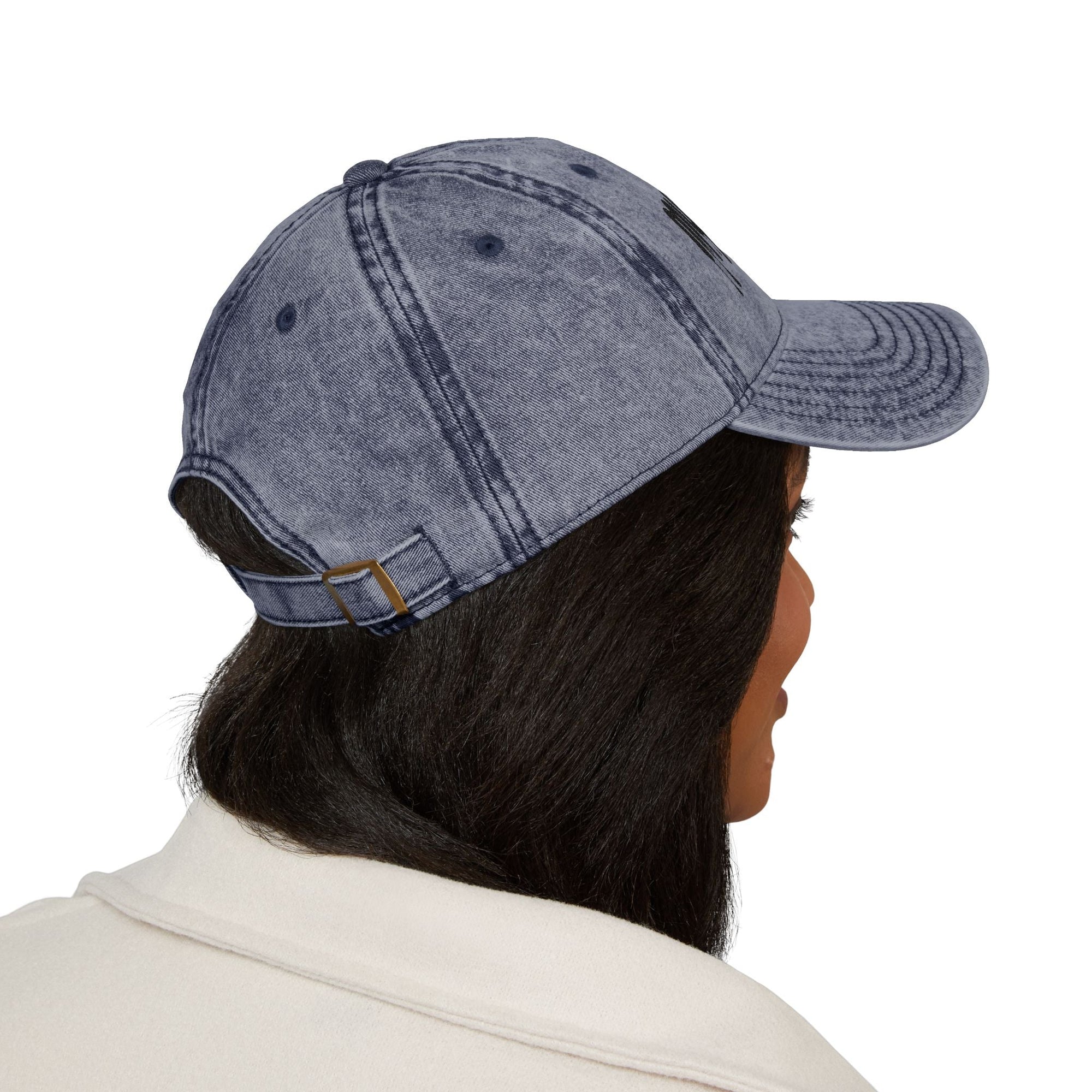 Side view of a person wearing distressed navy blue Muala® "sunday pizza" cap with black embroidered logo on the right front panel and adjustable antique brass metal buckle at the back