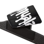 Close-up of black Muala® "flip fat flop" men's sandal strap with white graphic and textured footbed