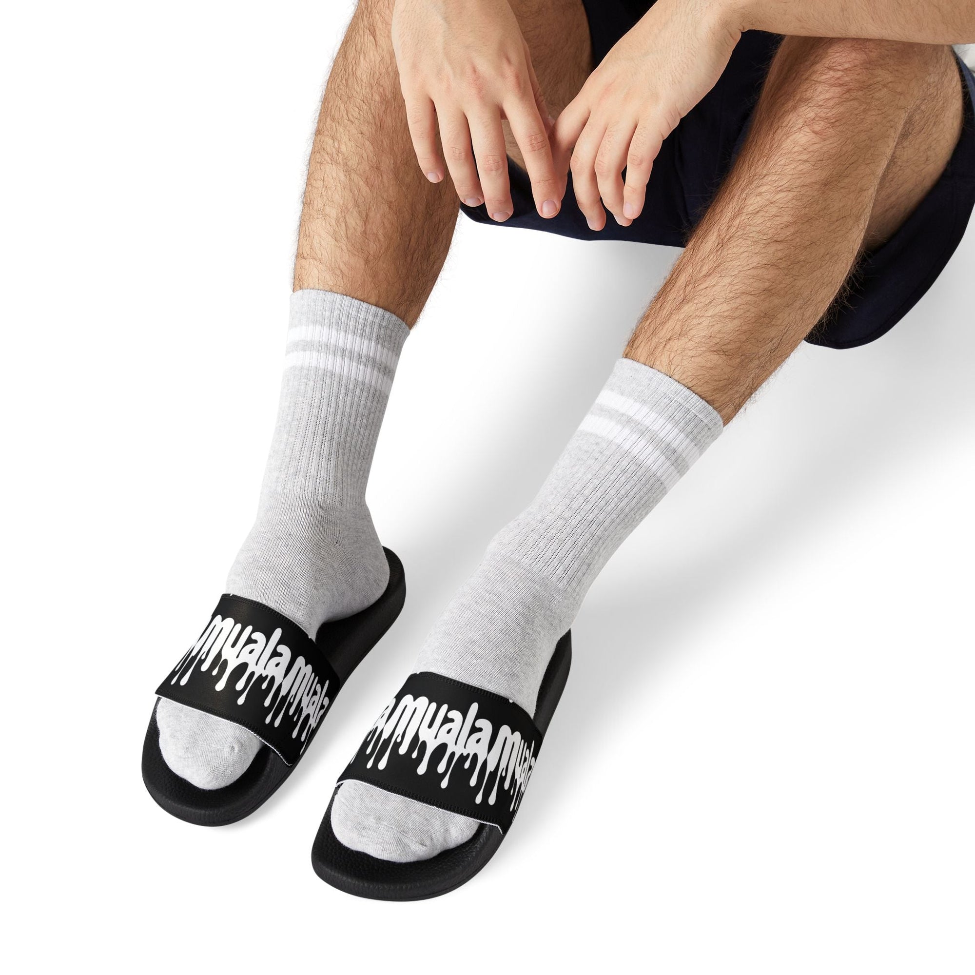 Muale flip fat flop men's sandals with black cushioned soles and bold white logo straps worn with gray socks