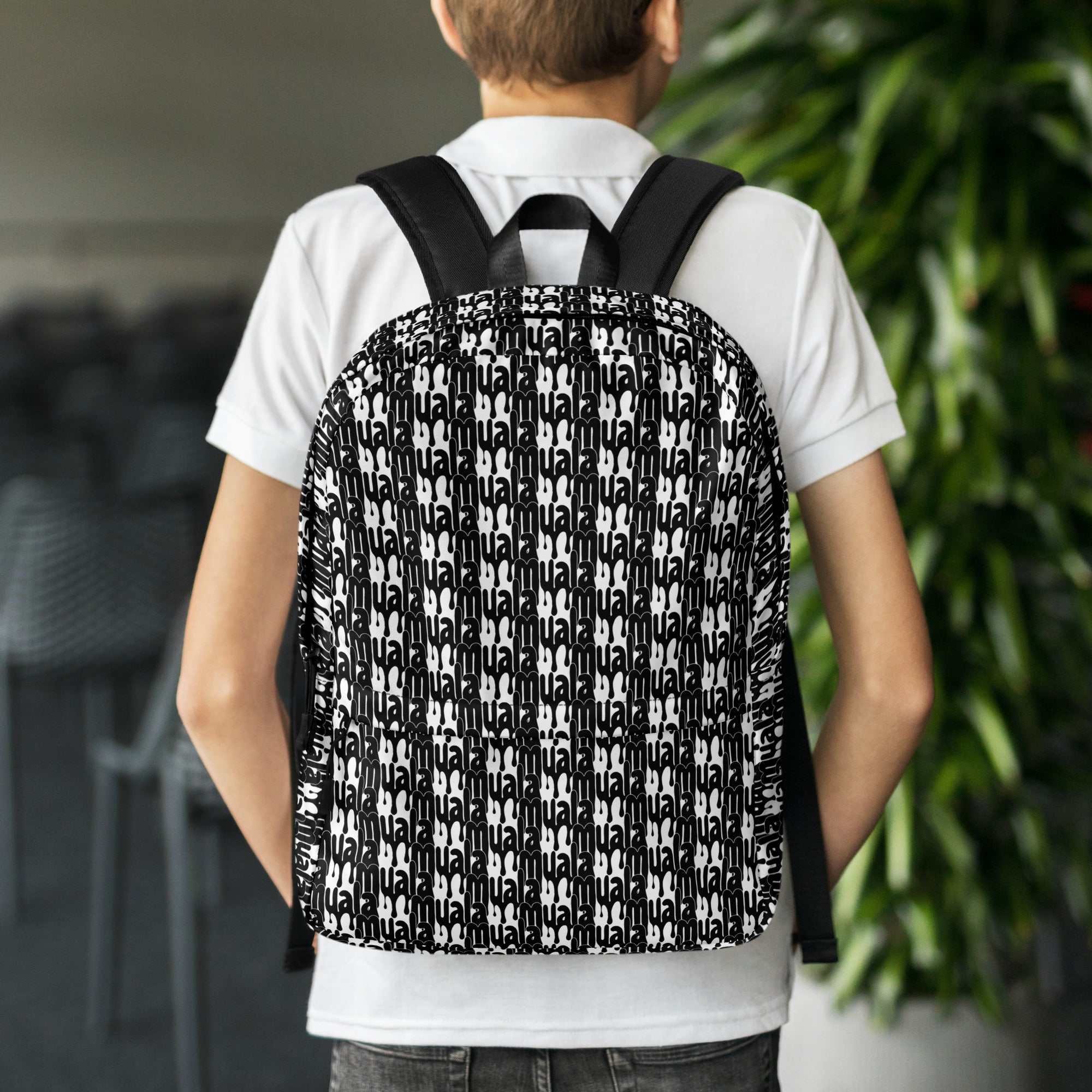 Person wearing muala® daily carry backpack with black and white pattern vol. 1 design on back.