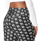 Close-up of black and white high-waisted leggings with repeating "muala" pattern and flared knee design, worn with a white long sleeve top.