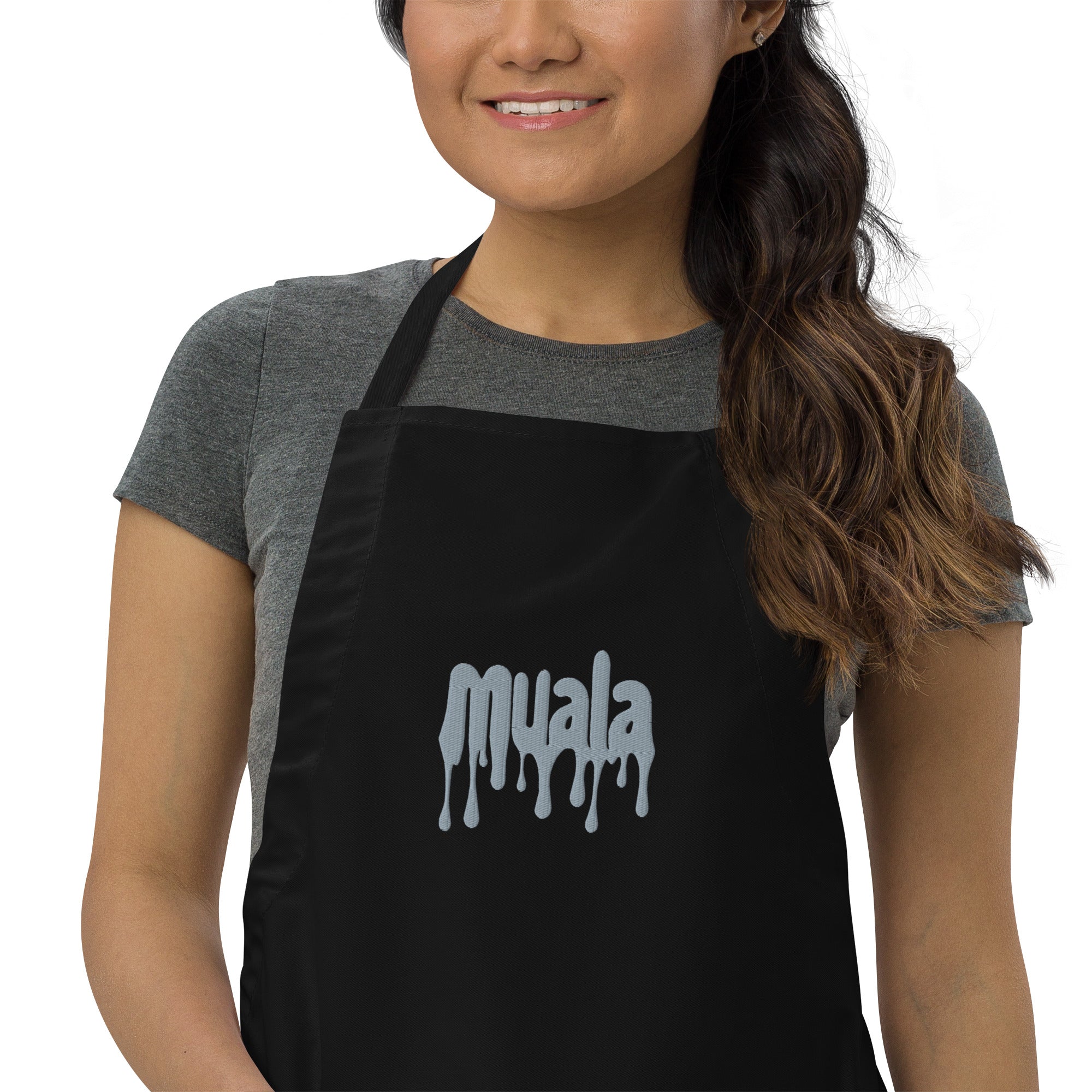 woman wearing black muala kitchen apron with gray embroidered logo and adjustable neck strap