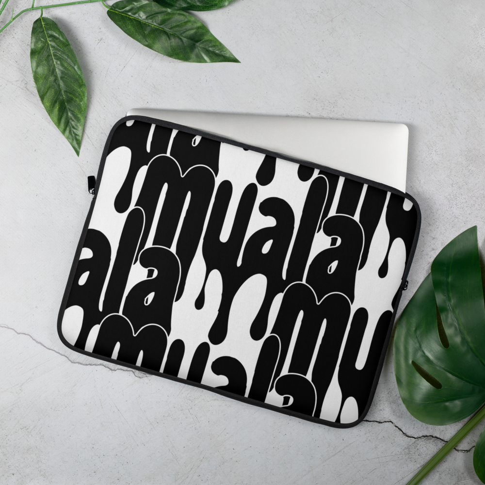 Black and white Muala® tech wrap laptop sleeve with bold Pattern Vol.1 streetwear graphics partially covering a laptop on a gray surface with green leaves nearby