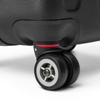 Close-up of black travel wrap suitcase 360-degree double wheels with red accent and textured polycarbonate shell